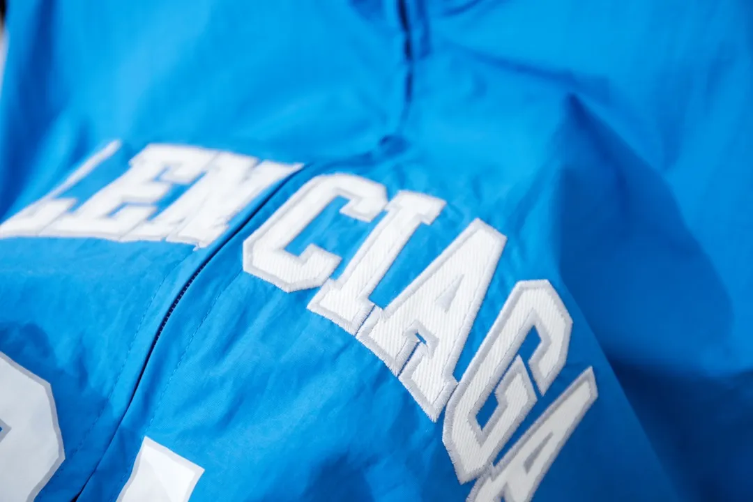 Balenciaga 𝘽𝘼𝙇𝙀𝙉𝘾𝙄𝘼𝙂𝘼 BLCG 26SS 77 Half Ring 01 Embroidered Basketball Jacket Light luxury essential item for daily commuting for men and women Correct version Welcome to compare Detailed features · Customized matt Taslan jacket fabric · The entire fabric is pre-treated with a waterproof coating · The interior is made of three-grade polyester bird's eye mesh · OS ultra-loose silhouette design · Side zipper pockets Small stand-up collar design · Internal zipper pocket design · Elastic waistband design at the hem · Customized molded hardware zipper Jacket double puller design · Laser engraved patch burning process · Imported environmentally friendly glue thermoset ink printing process · Original main mark washable tag brand packaging Color: White/Blue Size: 46/48/50/52